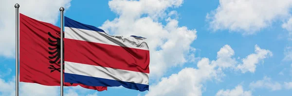 Флаг Албании и Коста-Рики размахивает ветром против белого облачно-синего неба вместе. Концепция дипломатии, международные отношения . — стоковое фото