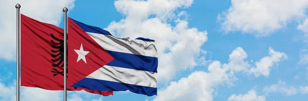 Albânia e Cuba bandeira acenando no vento contra o céu azul nublado branco juntos. Conceito de diplomacia, relações internacionais . — Fotografia de Stock