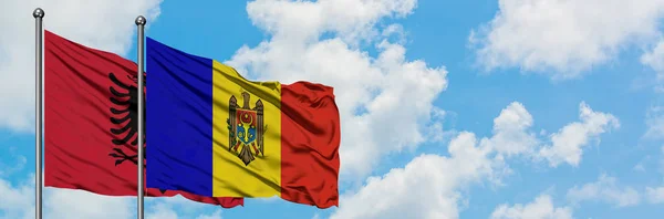 Bandera de Albania y Moldavia ondeando en el viento contra el cielo azul nublado blanco juntos. Concepto diplomático, relaciones internacionales . — Foto de Stock