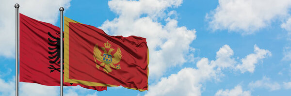 Albania and Montenegro flag waving in the wind against white cloudy blue sky together. Diplomacy concept, international relations.