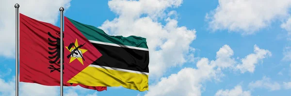 Albania and Mozambique flag waving in the wind against white cloudy blue sky together. Diplomacy concept, international relations. — Stock Photo, Image