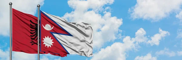 Albania and Nepal flag waving in the wind against white cloudy blue sky together. Diplomacy concept, international relations. — Stock Photo, Image