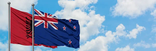 Албанія і Нова Зеландія прапор розмахуючи в вітру проти білого хмарного синього неба разом. Концепція дипломатії, міжнародні відносини. — стокове фото