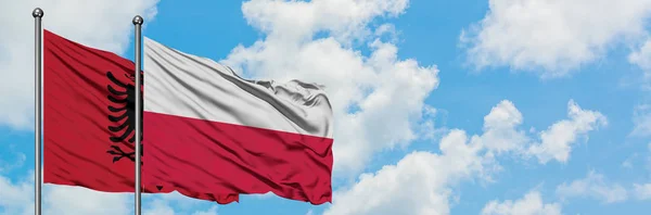 Albania and Poland flag waving in the wind against white cloudy blue sky together. Diplomacy concept, international relations. — Stock Photo, Image