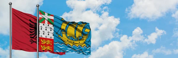 Albanien und Saint Pierre und miquelon Flagge wehen im Wind vor weißem wolkenblauem Himmel zusammen. Diplomatie-Konzept, internationale Beziehungen. — Stockfoto
