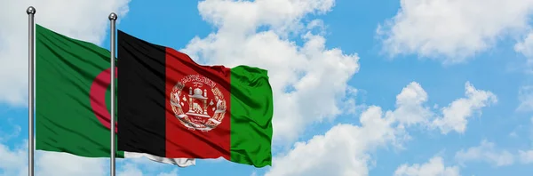 Bandera de Argelia y Afganistán ondeando en el viento contra el cielo azul nublado blanco juntos. Concepto diplomático, relaciones internacionales . — Foto de Stock