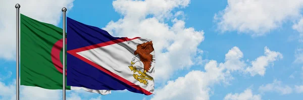 Argelia y Samoa Americana ondeando en el viento contra el cielo azul nublado blanco juntos. Concepto diplomático, relaciones internacionales . — Foto de Stock