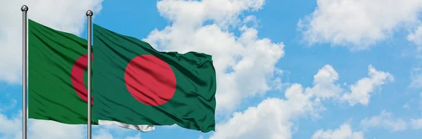 Bandera de Argelia y Bangladesh ondeando en el viento contra el cielo azul nublado blanco juntos. Concepto diplomático, relaciones internacionales . — Foto de Stock