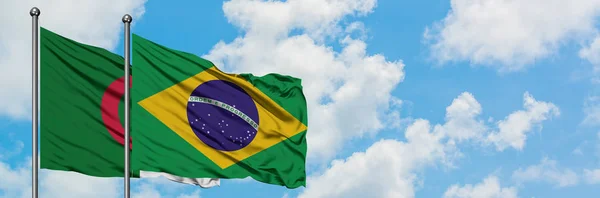 Algeria and Brazil flag waving in the wind against white cloudy blue sky together. Diplomacy concept, international relations.