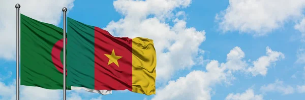 Bandera de Argelia y Camerún ondeando en el viento contra el cielo azul nublado blanco juntos. Concepto diplomático, relaciones internacionales . — Foto de Stock