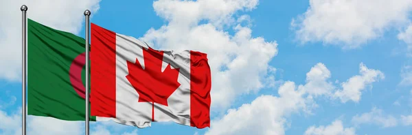 Bandera de Argelia y Canadá ondeando en el viento contra el cielo azul nublado blanco juntos. Concepto diplomático, relaciones internacionales . — Foto de Stock