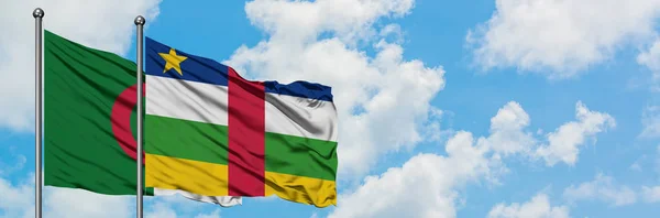 Bandera de Argelia y República Centroafricana ondeando en el viento contra el cielo azul nublado blanco juntos. Concepto diplomático, relaciones internacionales . — Foto de Stock