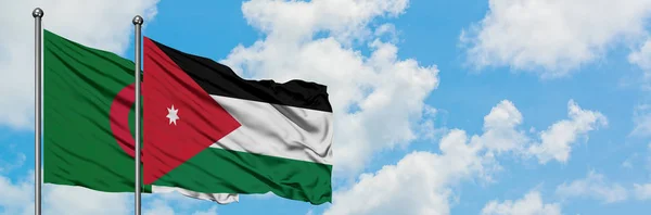 Bandera de Argelia y Jordania ondeando en el viento contra el cielo azul nublado blanco juntos. Concepto diplomático, relaciones internacionales . — Foto de Stock
