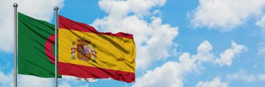 Cezayir ve İspanya bayrağı birlikte beyaz bulutlu mavi gökyüzüne karşı rüzgarsal sallayarak. Diplomasi kavramı, uluslararası ilişkiler.