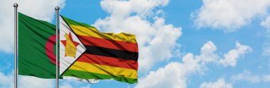 Cezayir ve Zimbabve bayrağı birlikte beyaz bulutlu mavi gökyüzüne karşı rüzgarda sallayarak. Diplomasi kavramı, uluslararası ilişkiler.