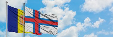 Andorra ve Faroe Adaları bayrağı birlikte beyaz bulutlu mavi gökyüzüne karşı rüzgarda sallayarak. Diplomasi kavramı, uluslararası ilişkiler.