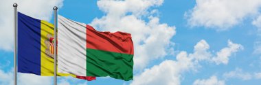 Andorra ve Madagaskar bayrağı birlikte beyaz bulutlu mavi gökyüzüne karşı rüzgarda sallayarak. Diplomasi kavramı, uluslararası ilişkiler.
