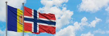 Andorra ve Norveç bayrağı birlikte beyaz bulutlu mavi gökyüzüne karşı rüzgarda sallayarak. Diplomasi kavramı, uluslararası ilişkiler.