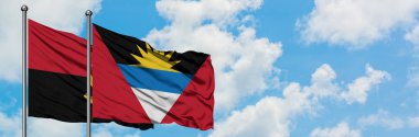 Angola ve Antigua ve Barbuda bayrağı birlikte beyaz bulutlu mavi gökyüzüne karşı rüzgarda sallayarak. Diplomasi kavramı, uluslararası ilişkiler.