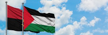Angola ve Filistin bayrağı birlikte beyaz bulutlu mavi gökyüzüne karşı rüzgarda sallayarak. Diplomasi kavramı, uluslararası ilişkiler.