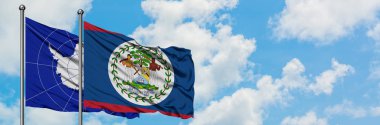 Antarktika ve Belize bayrağı birlikte beyaz bulutlu mavi gökyüzüne karşı rüzgarda sallayarak. Diplomasi kavramı, uluslararası ilişkiler.
