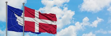 Antarktika ve Danimarka bayrağı birlikte beyaz bulutlu mavi gökyüzüne karşı rüzgarda sallayarak. Diplomasi kavramı, uluslararası ilişkiler.