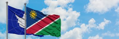 Antarktika ve Namibya bayrağı birlikte beyaz bulutlu mavi gökyüzüne karşı rüzgarda sallayarak. Diplomasi kavramı, uluslararası ilişkiler.