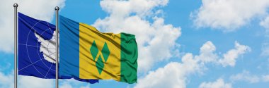 Antarktika ve Saint Vincent ve Grenadinler bayrak birlikte beyaz bulutlu mavi gökyüzüne karşı rüzgarda sallayarak. Diplomasi kavramı, uluslararası ilişkiler.