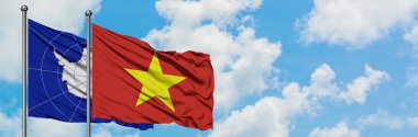 Antarktika ve Vietnam bayrağı birlikte beyaz bulutlu mavi gökyüzüne karşı rüzgarda sallayarak. Diplomasi kavramı, uluslararası ilişkiler.