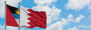 Antigua ve Barbuda Bahreyn bayrağı ile birlikte beyaz bulutlu mavi gökyüzüne karşı rüzgarda sallayarak. Diplomasi kavramı, uluslararası ilişkiler.