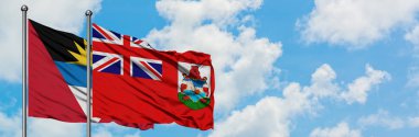 Antigua ve Barbuda Bermuda bayrağı ile birlikte beyaz bulutlu mavi gökyüzüne karşı rüzgarda sallayarak. Diplomasi kavramı, uluslararası ilişkiler.