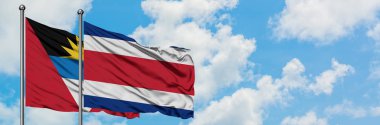 Antigua ve Barbuda Kosta Rika bayrağı ile birlikte beyaz bulutlu mavi gökyüzüne karşı rüzgarda sallayarak. Diplomasi kavramı, uluslararası ilişkiler.