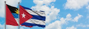 Antigua ve Barbuda Küba bayrağı ile birlikte beyaz bulutlu mavi gökyüzüne karşı rüzgarda sallayarak. Diplomasi kavramı, uluslararası ilişkiler.