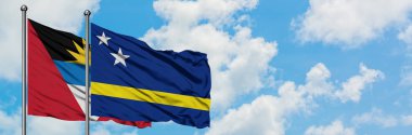 Antigua ve Barbuda Curacao bayrağı ile birlikte beyaz bulutlu mavi gökyüzüne karşı rüzgarda sallayarak. Diplomasi kavramı, uluslararası ilişkiler.