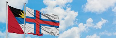 Antigua ve Barbuda Faroe Adaları bayrağı ile birlikte beyaz bulutlu mavi gökyüzüne karşı rüzgarda sallayarak. Diplomasi kavramı, uluslararası ilişkiler.
