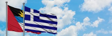 Antigua ve Barbuda Yunanistan bayrağı ile birlikte beyaz bulutlu mavi gökyüzüne karşı rüzgarda sallayarak. Diplomasi kavramı, uluslararası ilişkiler.