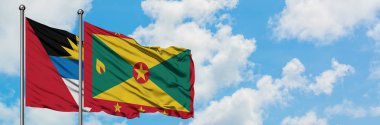 Antigua ve Grenada bayrağı ile Barbuda birlikte beyaz bulutlu mavi gökyüzüne karşı rüzgarda sallayarak. Diplomasi kavramı, uluslararası ilişkiler.