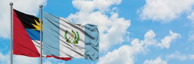 Antigua ve Barbuda Guatemala bayrağı ile birlikte beyaz bulutlu mavi gökyüzüne karşı rüzgarda sallayarak. Diplomasi kavramı, uluslararası ilişkiler.