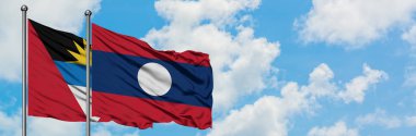 Antigua ve Barbuda Laos bayrağı ile birlikte beyaz bulutlu mavi gökyüzüne karşı rüzgarda sallayarak. Diplomasi kavramı, uluslararası ilişkiler.