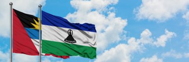 Antigua ve Barbuda Lesotho bayrağı ile birlikte beyaz bulutlu mavi gökyüzüne karşı rüzgarda sallayarak. Diplomasi kavramı, uluslararası ilişkiler.