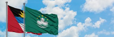 Antigua ve Barbuda Macao bayrağı ile birlikte beyaz bulutlu mavi gökyüzüne karşı rüzgarda sallayarak. Diplomasi kavramı, uluslararası ilişkiler.