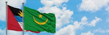 Antigua ve Barbuda Moritanya bayrağı ile birlikte beyaz bulutlu mavi gökyüzüne karşı rüzgarda sallayarak. Diplomasi kavramı, uluslararası ilişkiler.