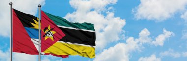Antigua ve Mozambik bayrağı ile Barbuda birlikte beyaz bulutlu mavi gökyüzüne karşı rüzgarda sallayarak. Diplomasi kavramı, uluslararası ilişkiler.