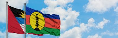 Antigua ve Barbuda Yeni Kaledonya bayrağı ile birlikte beyaz bulutlu mavi gökyüzüne karşı rüzgarda sallayarak. Diplomasi kavramı, uluslararası ilişkiler.