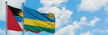 Antigua ve Barbuda Ruanda bayrağı ile birlikte beyaz bulutlu mavi gökyüzüne karşı rüzgarda sallayarak. Diplomasi kavramı, uluslararası ilişkiler.