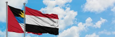 Antigua ve Barbuda Yemen bayrağı ile birlikte beyaz bulutlu mavi gökyüzüne karşı rüzgarsal sallayarak. Diplomasi kavramı, uluslararası ilişkiler.