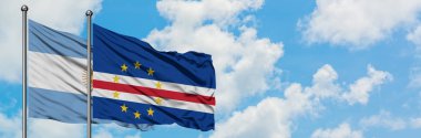 Arjantin ve Cape Verde bayrağı birlikte beyaz bulutlu mavi gökyüzüne karşı rüzgarda sallayarak. Diplomasi kavramı, uluslararası ilişkiler.