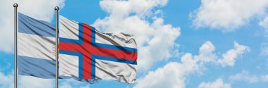Arjantin ve Faroe Adaları bayrağı birlikte beyaz bulutlu mavi gökyüzüne karşı rüzgarsal sallayarak. Diplomasi kavramı, uluslararası ilişkiler.