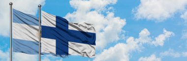 Arjantin ve Finlandiya bayrağı birlikte beyaz bulutlu mavi gökyüzüne karşı rüzgarsal sallayarak. Diplomasi kavramı, uluslararası ilişkiler.