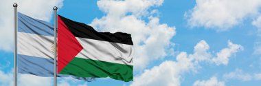 Arjantin ve Filistin bayrağı birlikte beyaz bulutlu mavi gökyüzüne karşı rüzgarda sallayarak. Diplomasi kavramı, uluslararası ilişkiler.